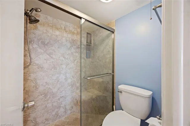 a bathroom with a toilet and a shower