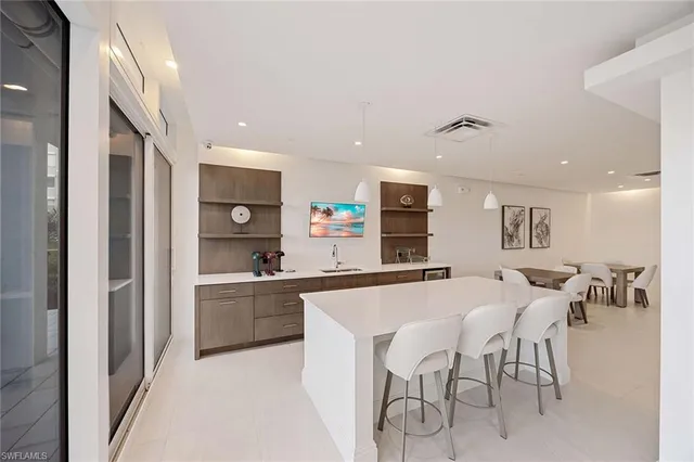 a kitchen with stainless steel appliances a table and chairs in it