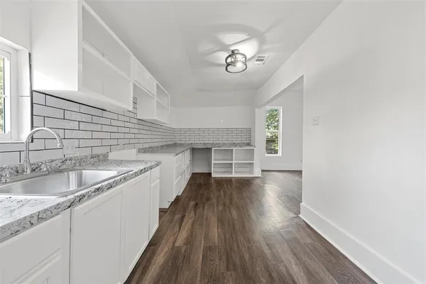 a view of a kitchen sink and wooden floor