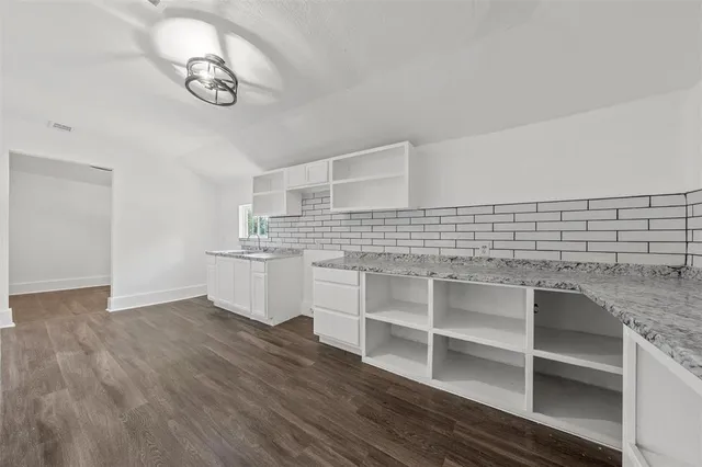 a view of a kitchen with cabinets and wooden floor