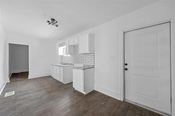 a kitchen with a refrigerator and white cabinets