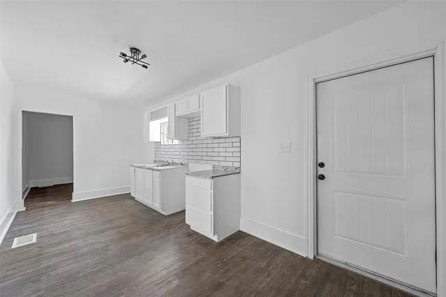 a kitchen with a refrigerator and white cabinets
