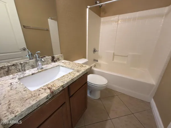a bathroom with a granite countertop sink a toilet and bathtub