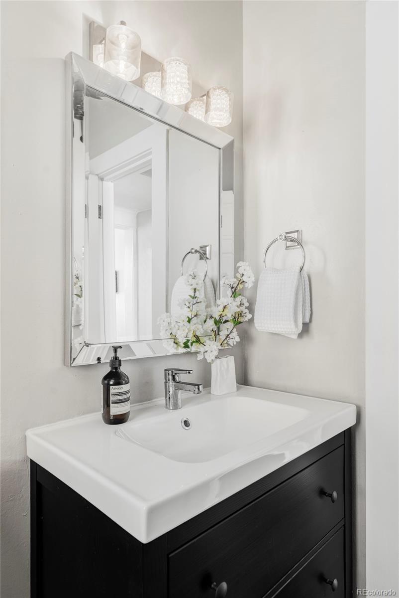 142 Logan Street Denver, CO 80203 - Photo 12 of 32 a bathroom with a sink and a mirror