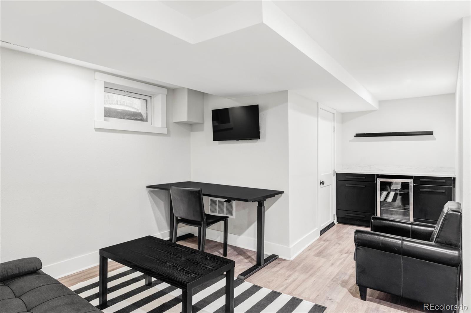 142 Logan Street Denver, CO 80203 - Photo 21 of 32 a living room with furniture and a flat screen tv