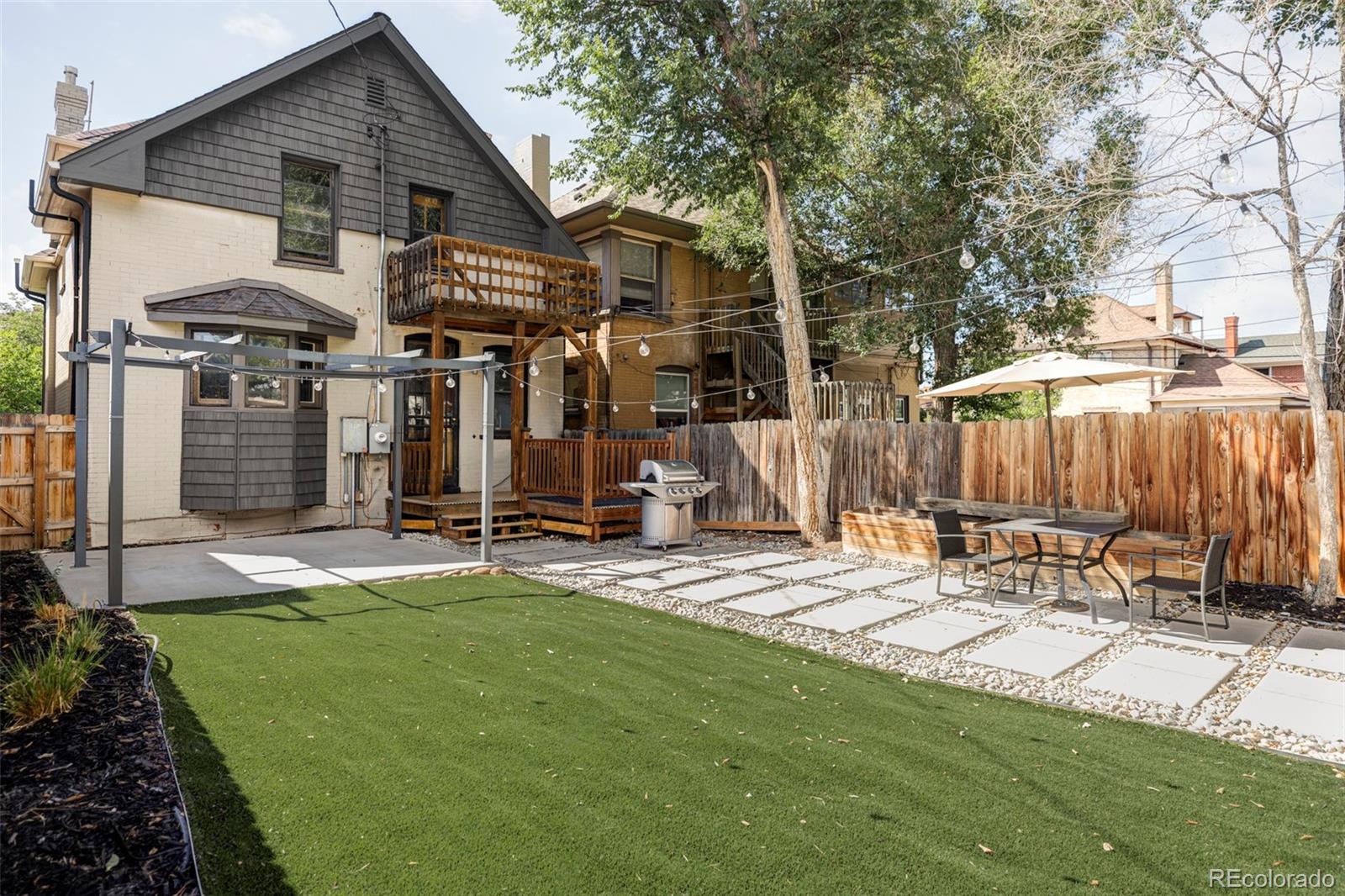 142 Logan Street Denver, CO 80203 - Photo 28 of 32 a view of a house with backyard and a tree
