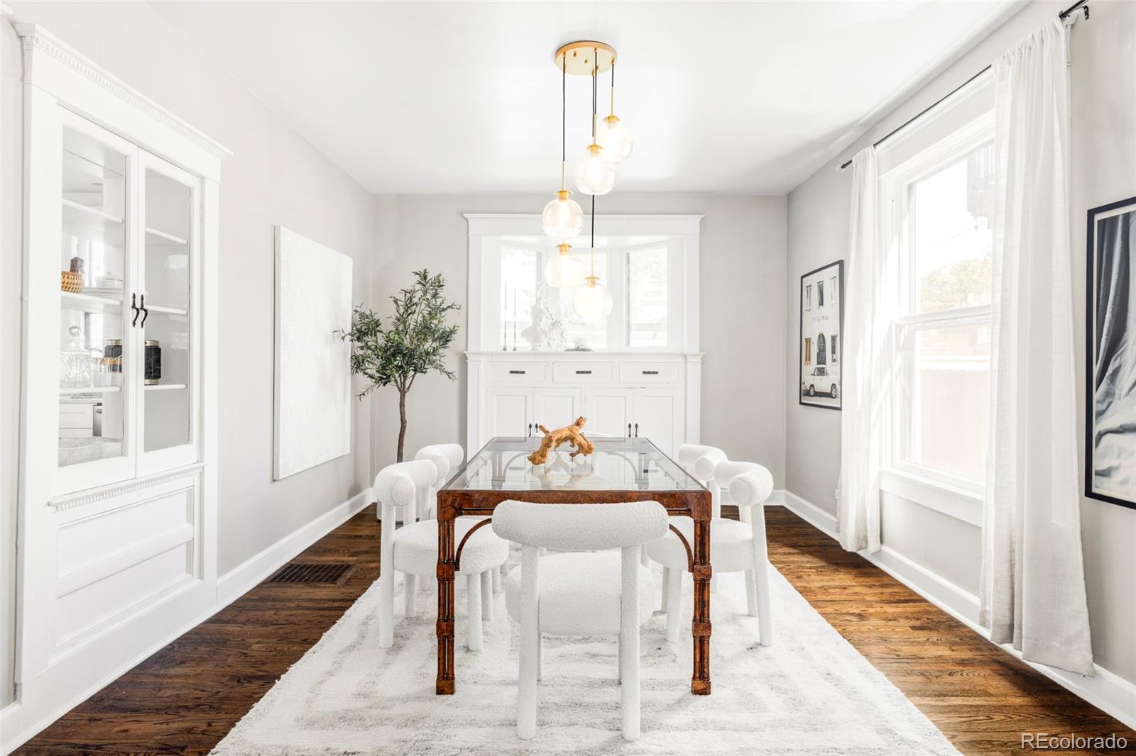 142 Logan Street Denver, CO 80203 - Photo 3 of 32 a dining room with furniture a chandelier and wooden floor