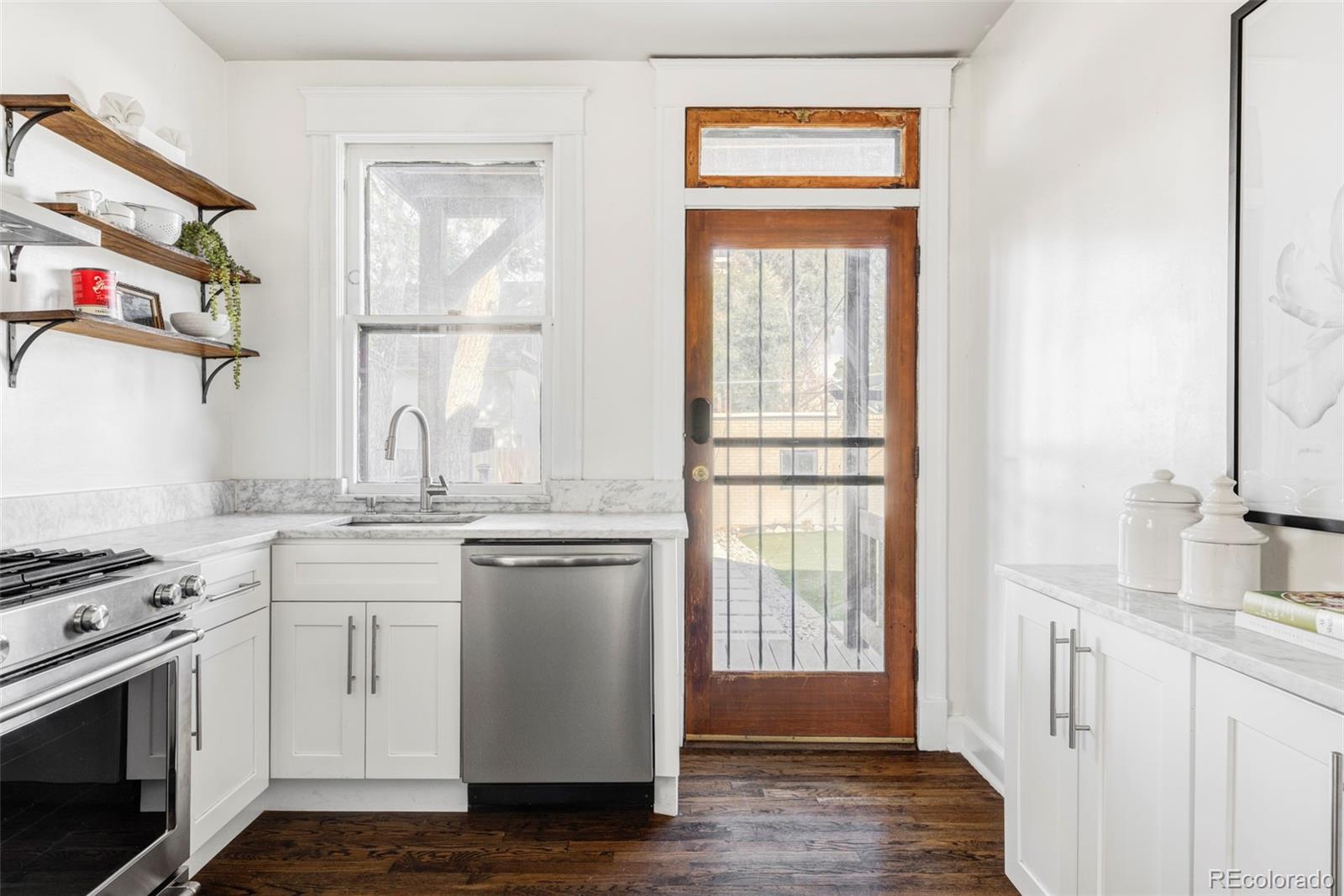 142 Logan Street Denver, CO 80203 - Photo 10 of 32 a kitchen with stainless steel appliances granite countertop a stove and a sink