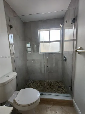 a bathroom with a toilet and a shower