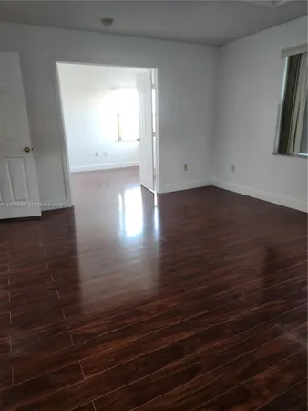 a view of a room with wooden floor and cabinets