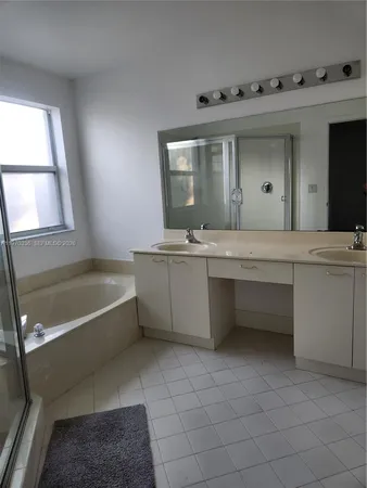 a bathroom with a bathtub sink and mirror