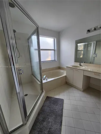 a bathroom with a tub sink and mirror