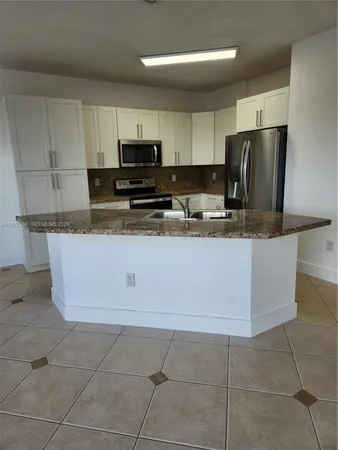 a kitchen with stainless steel appliances granite countertop a stove a sink a microwave and a refrigerator