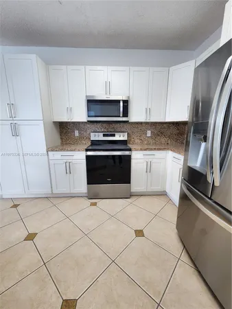 a kitchen with stainless steel appliances granite countertop a refrigerator sink and stove