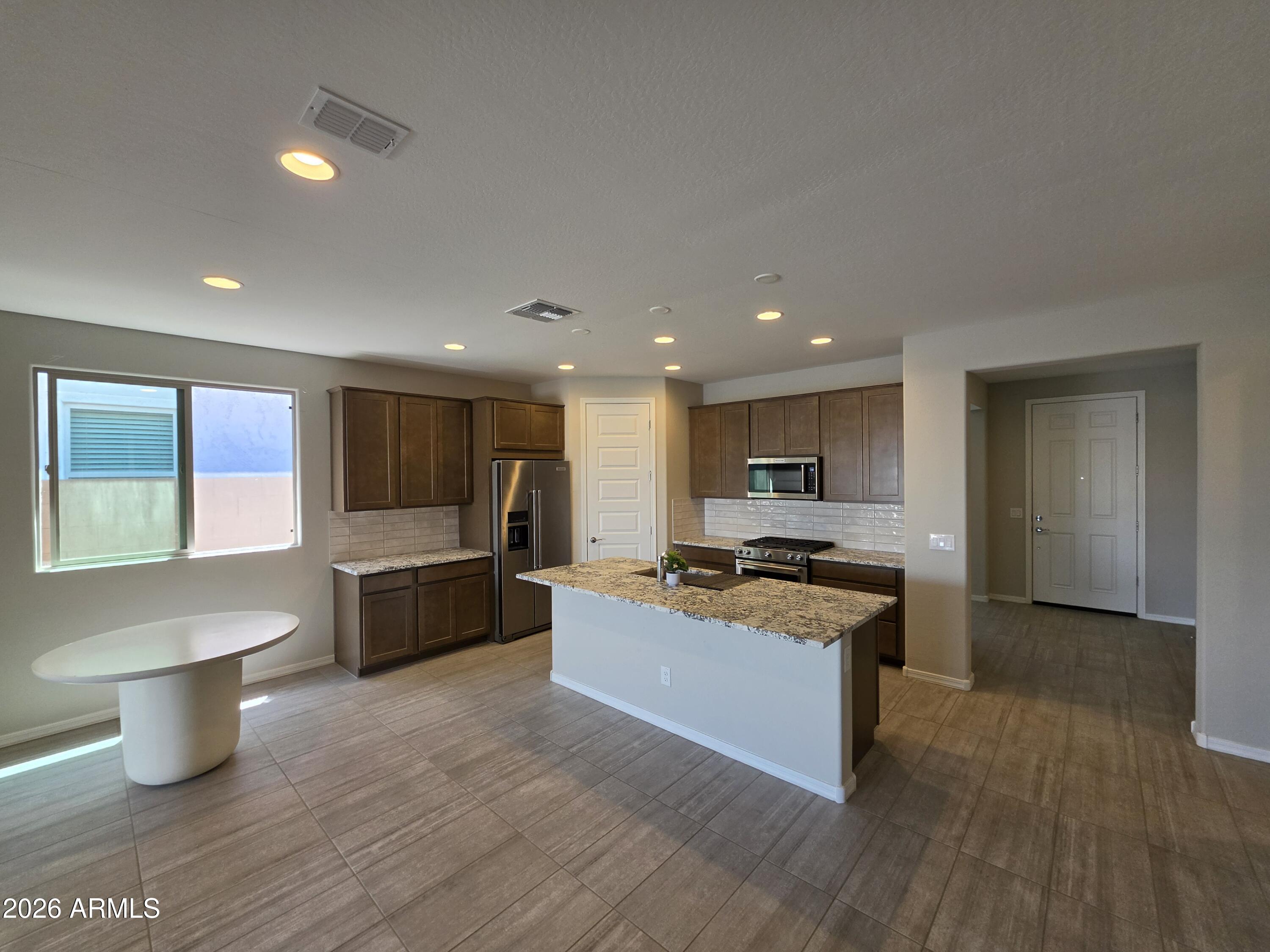 7128 West Coles Road Laveen, AZ 85339 - Photo 2 of 38 a kitchen with a stove a sink and a refrigerator