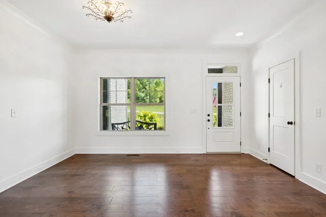 an empty room with window and wooden floor