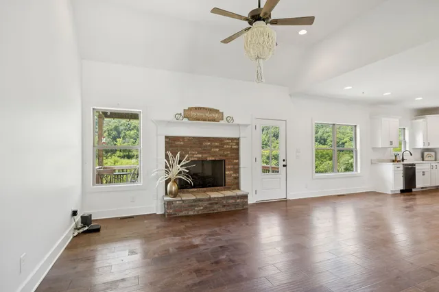 a view of an empty room with a window and fireplace