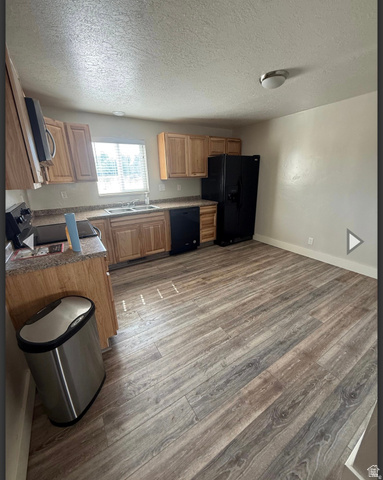 106 East Richelman Lane Wellington, UT 84542 - Photo 17 of 35 Kitchen featuring a textured ceiling, black appliances, dark wood-type flooring, and dark countertops