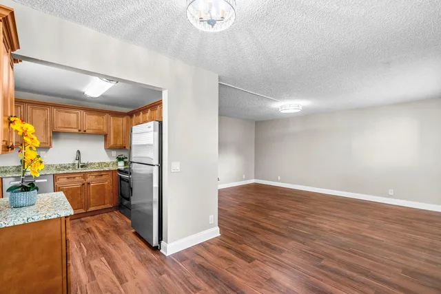 a view of a kitchen with wooden floor and electronic appliances