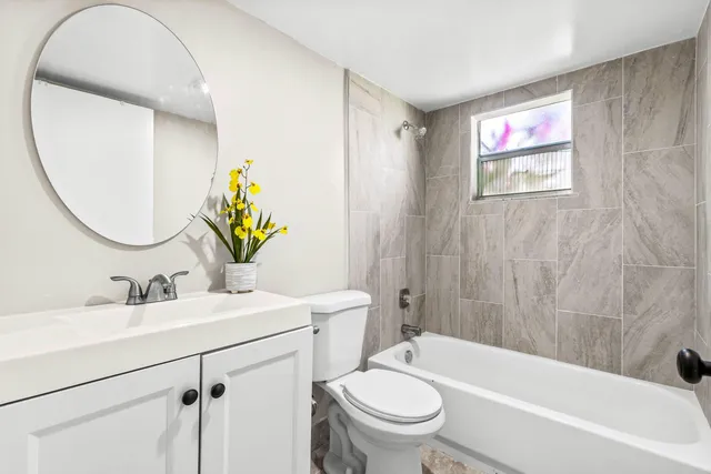 a bathroom with a sink mirror vanity and toilet