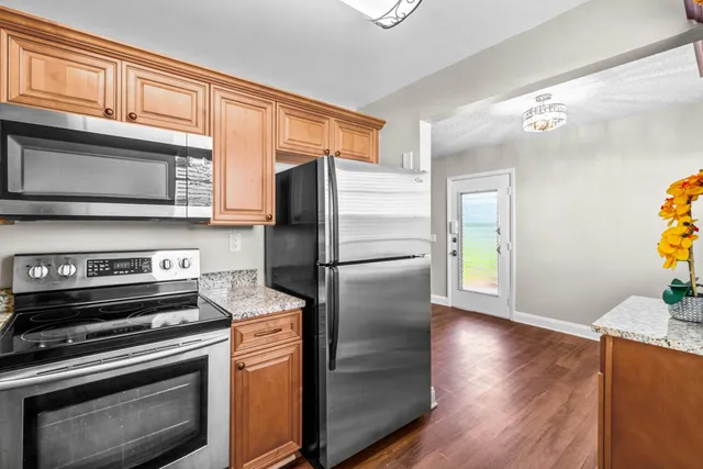 a kitchen with stainless steel appliances granite countertop a refrigerator microwave and stove