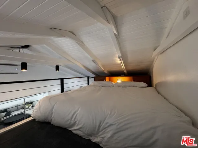 a bedroom with a bed and a night stand