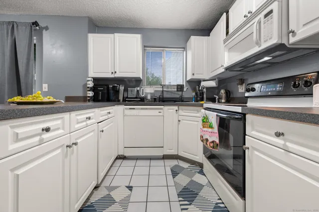a kitchen with white cabinets appliances and a sink