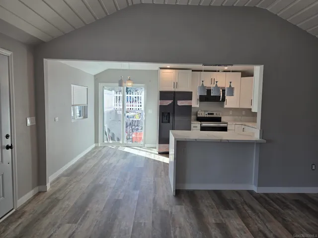 a kitchen with stainless steel appliances a refrigerator and a stove top oven