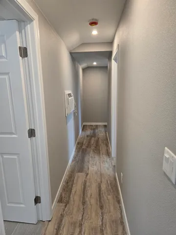a view of a closet area with wooden floor
