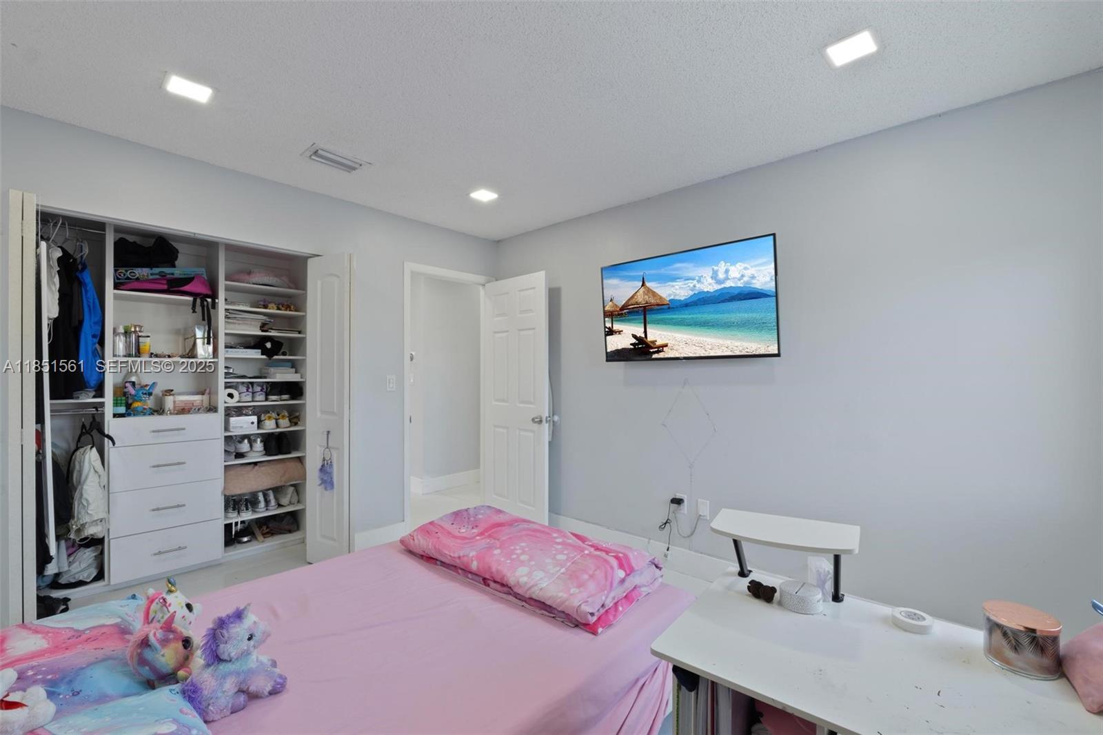 14725 Southwest 90th Terrace Miami, FL 33196 - Photo 23 of 50 a bedroom with a bed and a book shelf