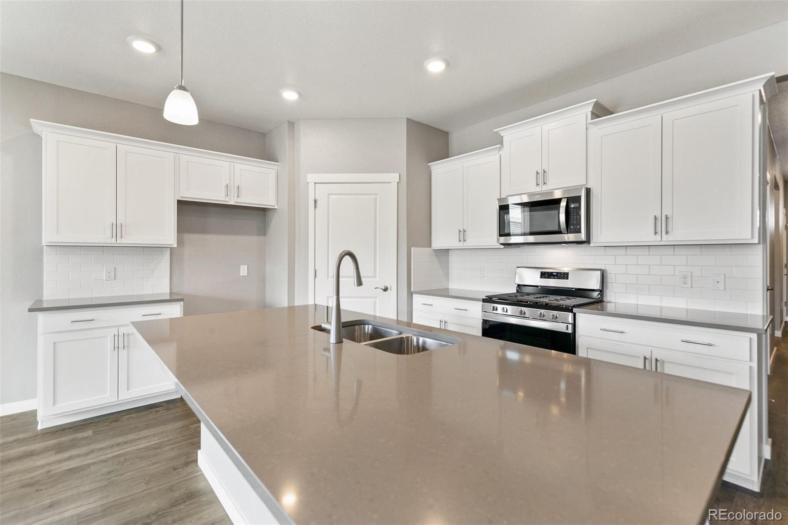 3458 Belleville Ridge Road Elizabeth, CO 80107 - Photo 12 of 27 a kitchen with kitchen island white cabinets and appliances