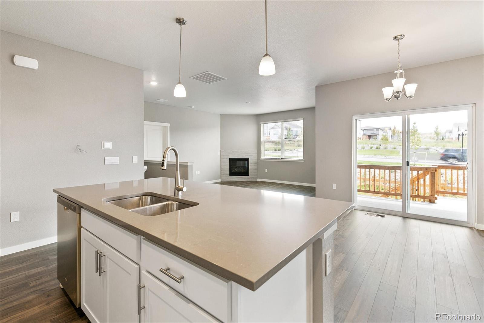3458 Belleville Ridge Road Elizabeth, CO 80107 - Photo 14 of 27 a kitchen with center island wooden floor and large windows