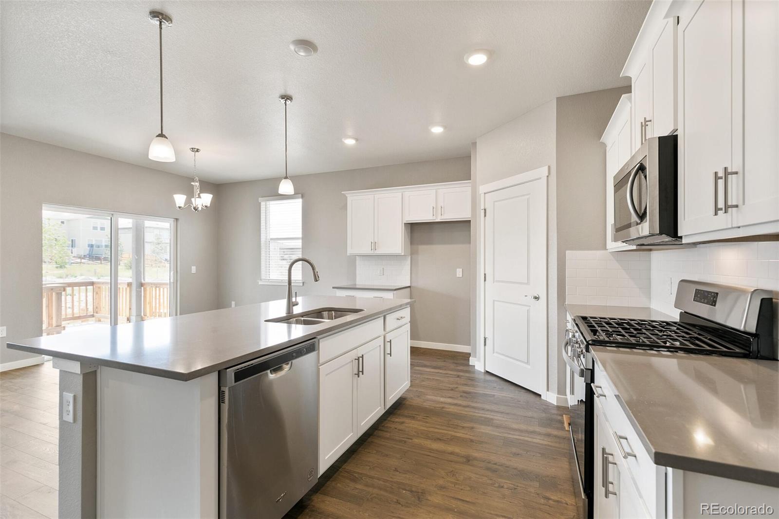 3458 Belleville Ridge Road Elizabeth, CO 80107 - Photo 15 of 27 a kitchen with stainless steel appliances granite countertop a sink stove and refrigerator