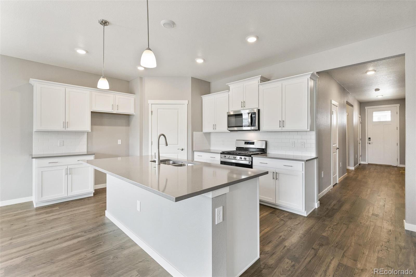 3458 Belleville Ridge Road Elizabeth, CO 80107 - Photo 9 of 27 a large white kitchen with lots of counter space a sink appliances and cabinets
