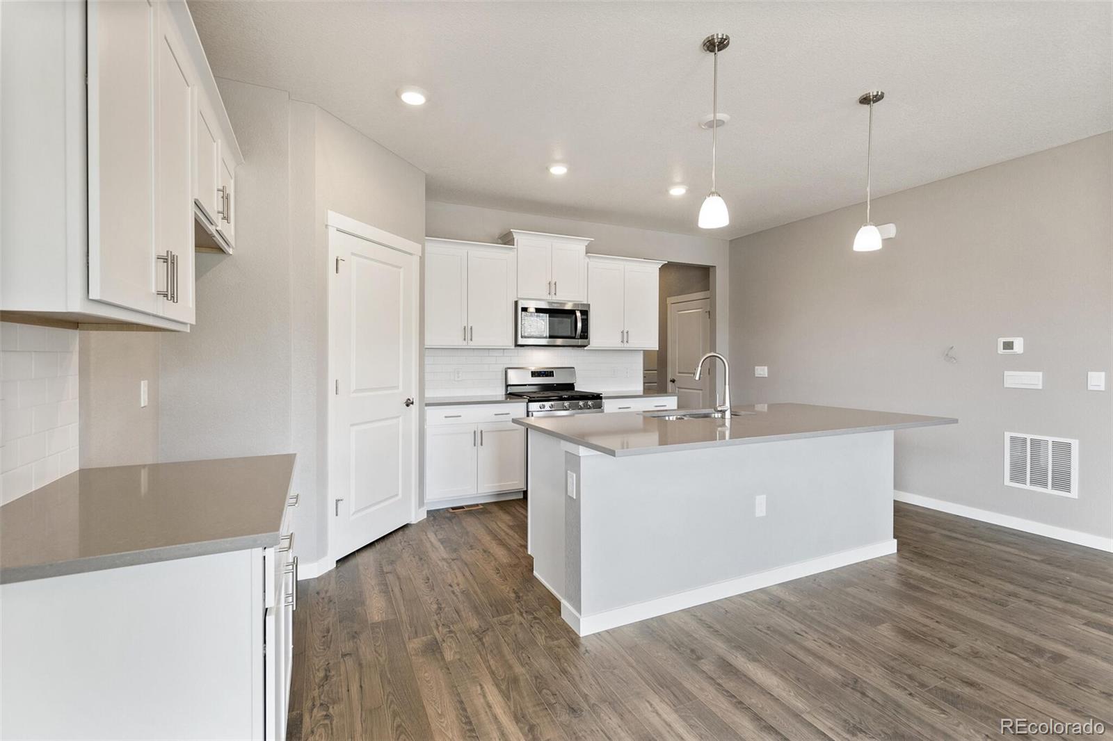 3458 Belleville Ridge Road Elizabeth, CO 80107 - Photo 10 of 27 a large kitchen with granite countertop a large counter top a sink stainless steel appliances and cabinets