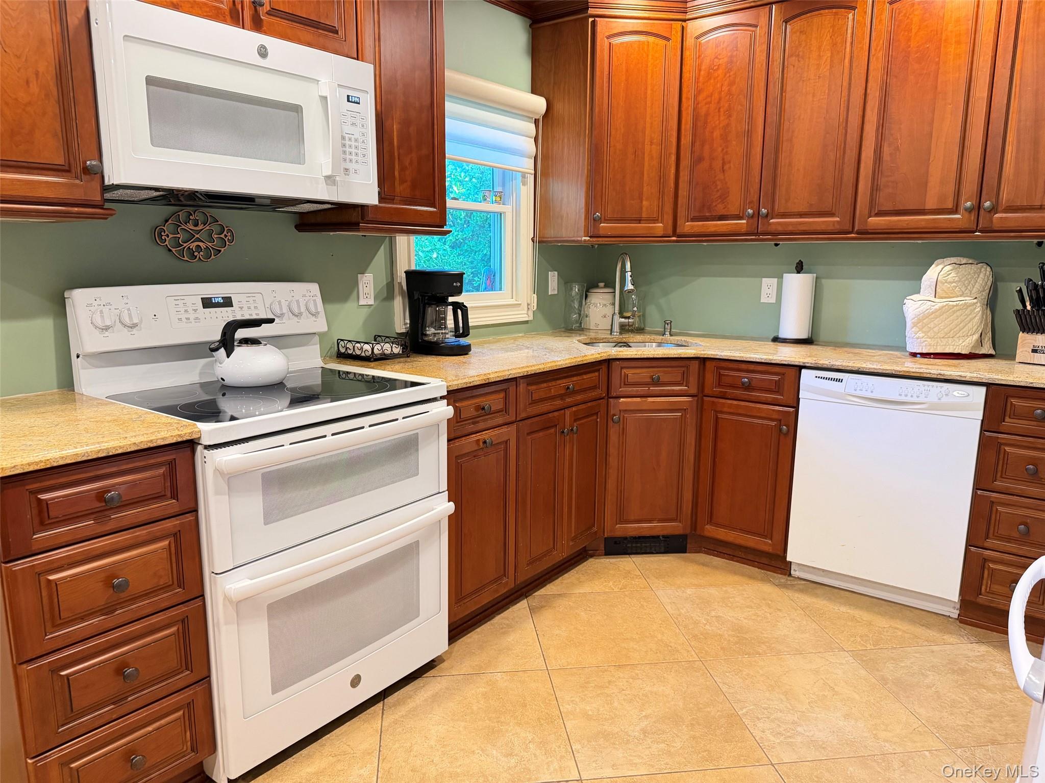 304 Dare Road Selden, NY 11784 - Photo 10 of 24 Full kitchen featuring wood cabinetry, light-toned countertops, tiled flooring, an electric range with double ovens, and an over-range microwave