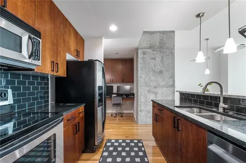a kitchen with a sink a refrigerator a stove and cabinets
