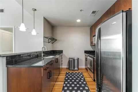 a kitchen with stainless steel appliances granite countertop a sink a refrigerator and a stove