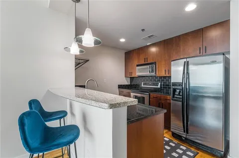 a kitchen with granite countertop a stove and a refrigerator