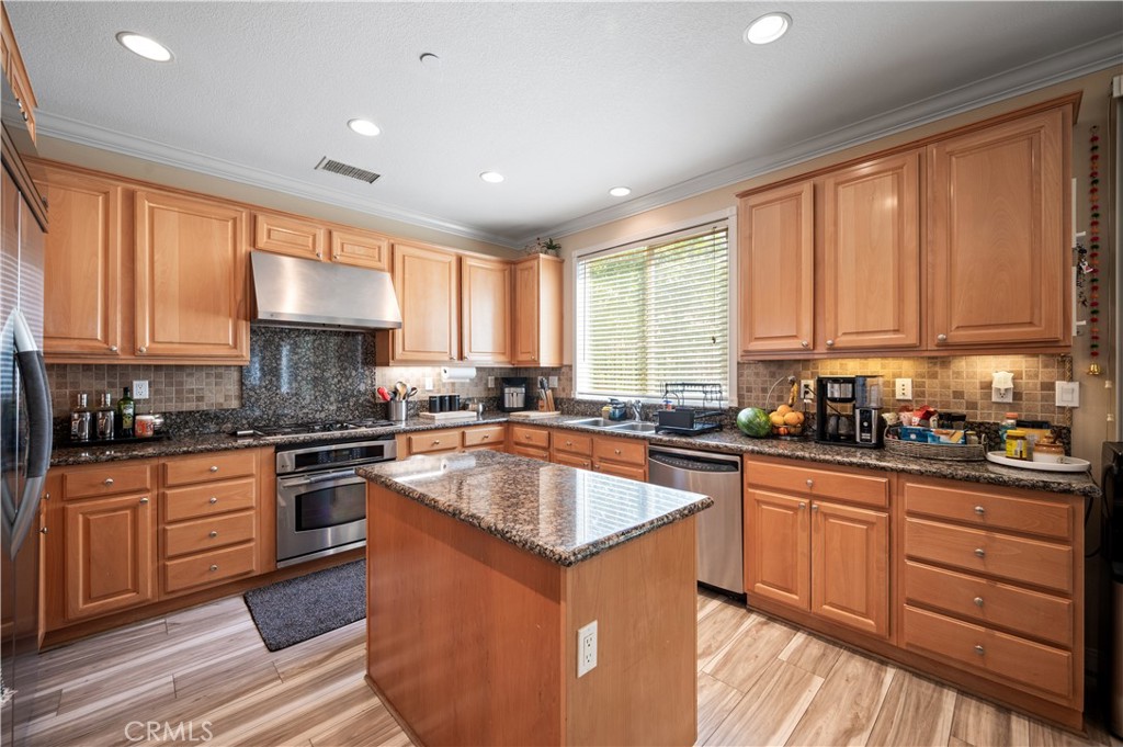 5588 California Oak Street Simi Valley, CA 93063 - Photo 27 of 75 a kitchen with stainless steel appliances granite countertop wooden cabinets a sink and a stove