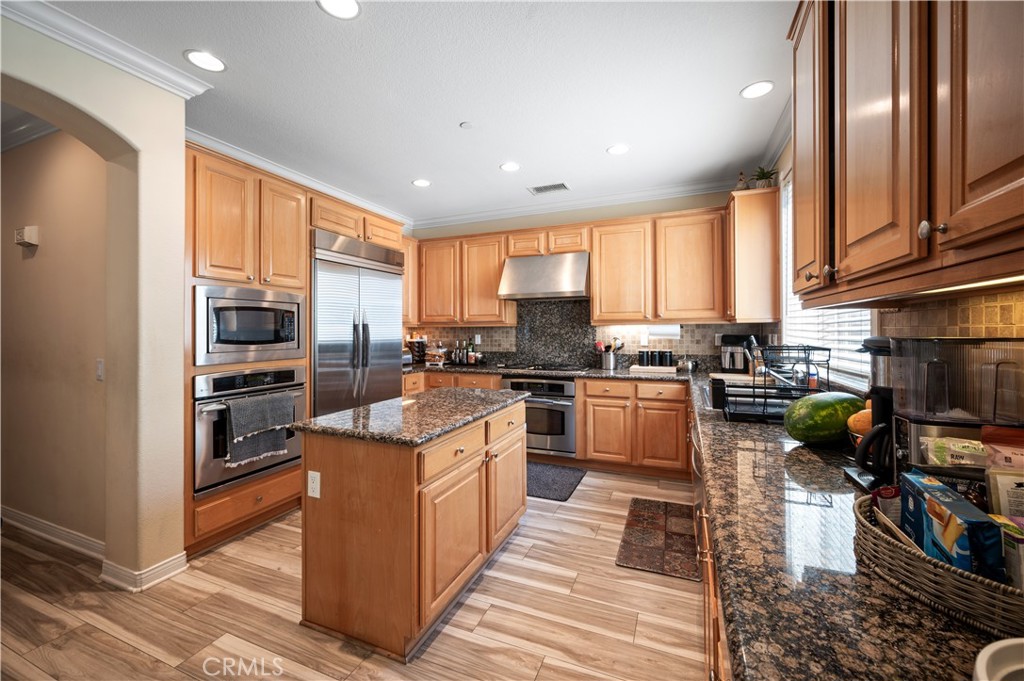5588 California Oak Street Simi Valley, CA 93063 - Photo 31 of 75 a kitchen with stainless steel appliances granite countertop a refrigerator a sink dishwasher a stove and white cabinets with wooden floor