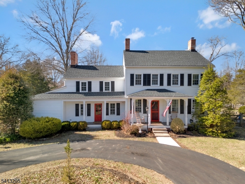 a front view of a house with yard and trees around