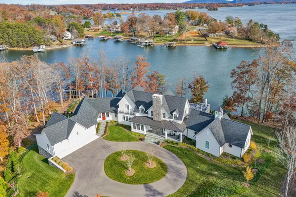 an aerial view of a house with swimming pool and lake view
