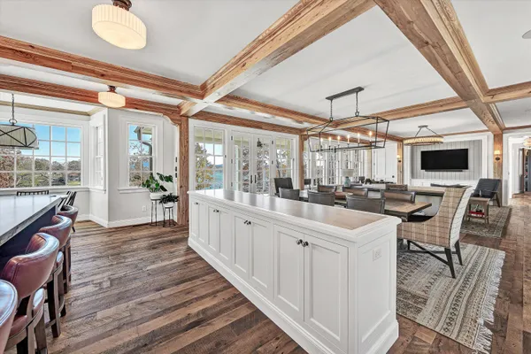 a view of a hallway with wooden floor and a bathroom