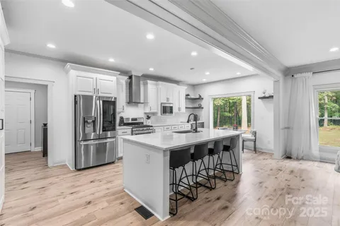 a kitchen with stainless steel appliances kitchen island granite countertop a refrigerator and a stove top oven