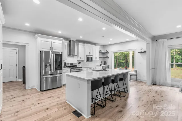 a kitchen with stainless steel appliances kitchen island granite countertop a refrigerator and a stove top oven