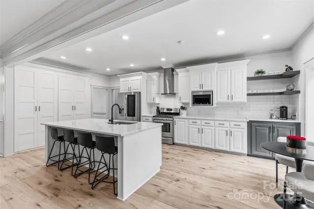 a kitchen with cabinets a sink and chairs in it