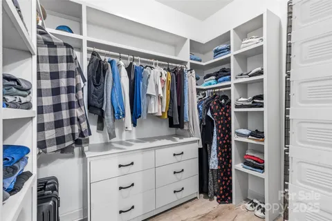 a view of walk in closet with clothes and shoes