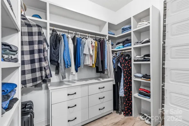 a view of walk in closet with clothes and shoes