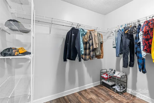 a view of walk in closet with clothes and shoes